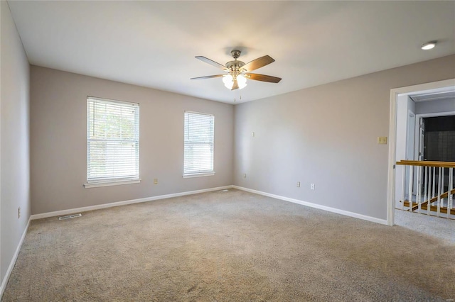 carpeted spare room featuring ceiling fan