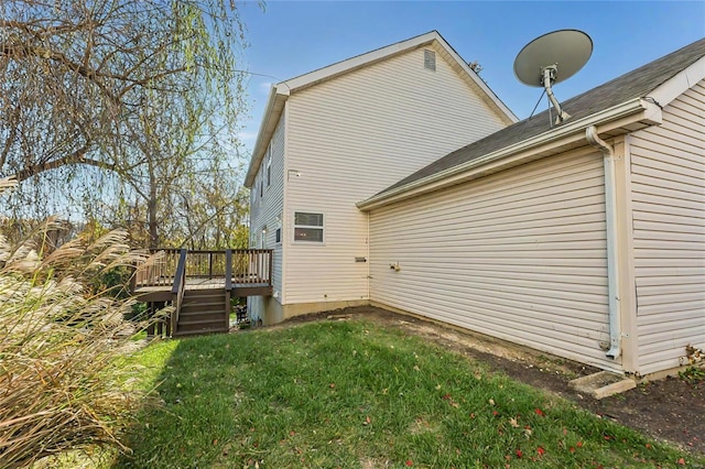 back of property featuring a deck and a lawn