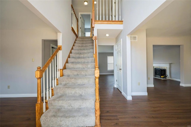 staircase with hardwood / wood-style flooring and a towering ceiling