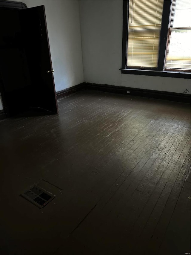 spare room with dark wood-type flooring