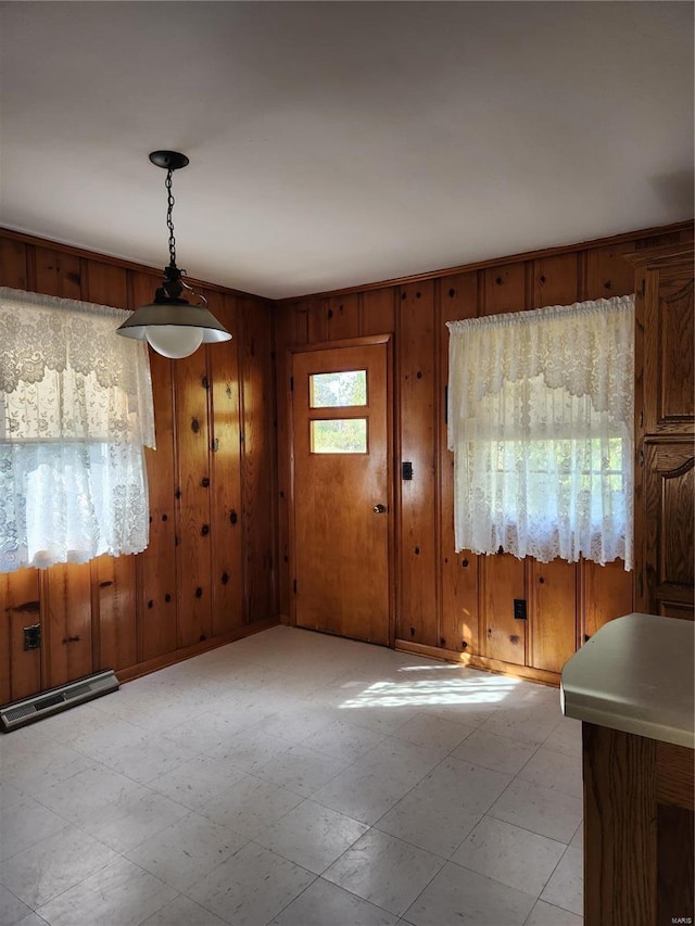 unfurnished dining area featuring wood walls