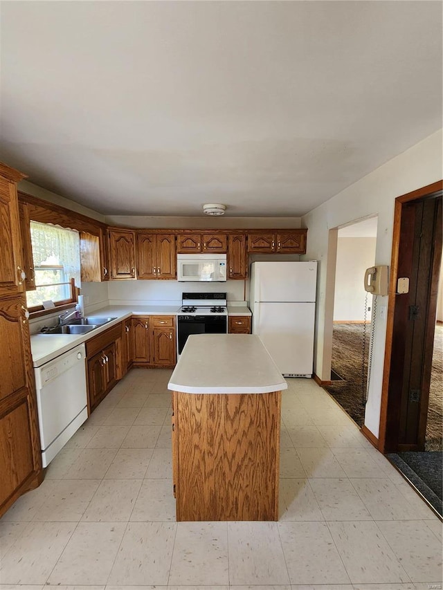 kitchen with sink, white appliances, and a center island