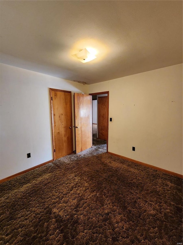 spare room with dark carpet