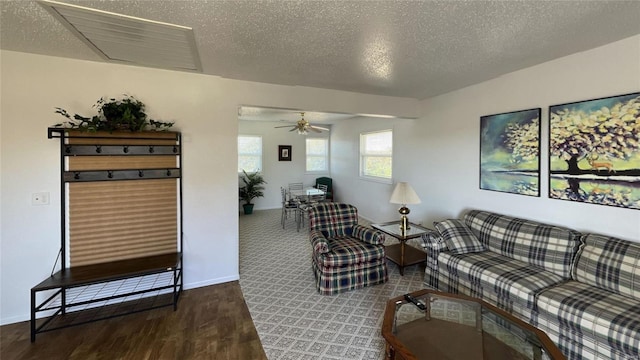 living room with a textured ceiling, dark hardwood / wood-style floors, and ceiling fan