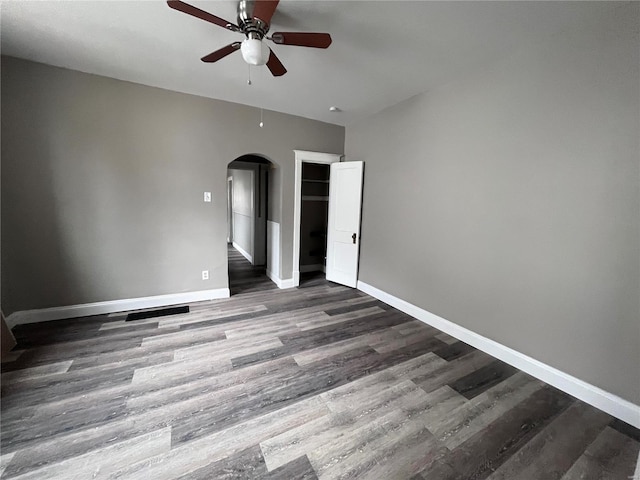 unfurnished bedroom featuring ceiling fan and dark wood-type flooring