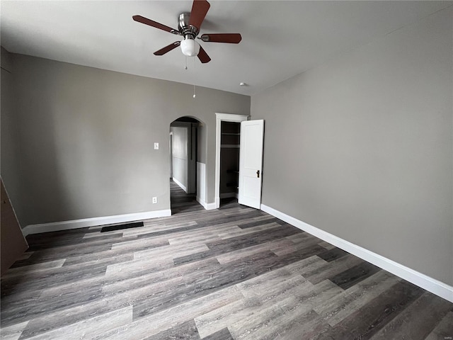 unfurnished bedroom with ceiling fan and dark wood-type flooring