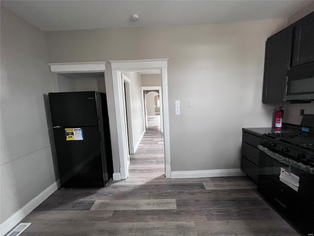 kitchen featuring dark hardwood / wood-style floors and black appliances