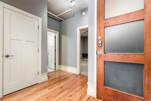 hall featuring light wood-style floors and baseboards