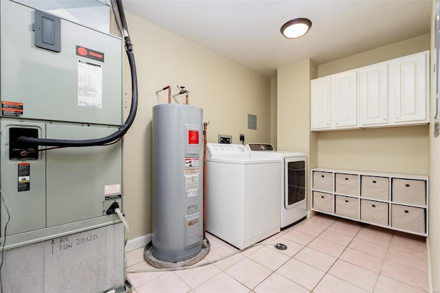 laundry area featuring cabinet space, light tile patterned floors, heating unit, water heater, and separate washer and dryer