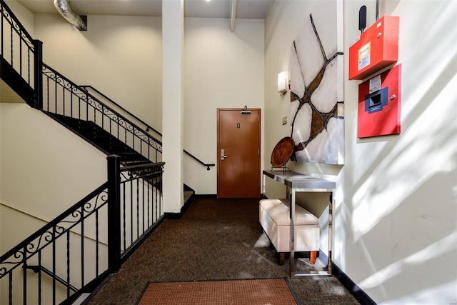 interior space featuring a towering ceiling and baseboards