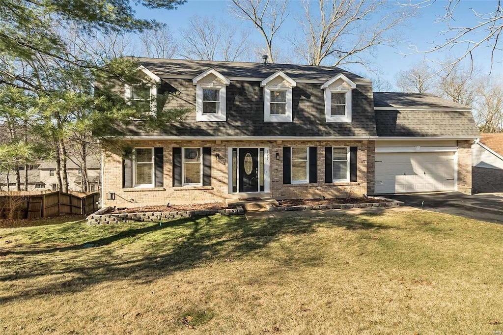 new england style home with a garage and a front lawn