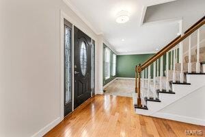 entryway featuring hardwood / wood-style floors and crown molding