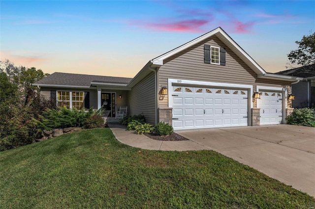 ranch-style house featuring a garage and a lawn