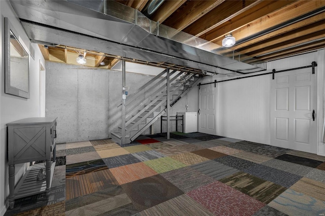 basement with dark carpet and a barn door