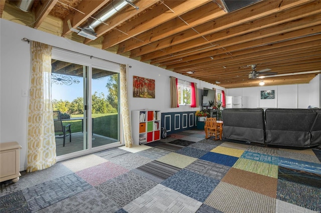 basement featuring ceiling fan and dark colored carpet