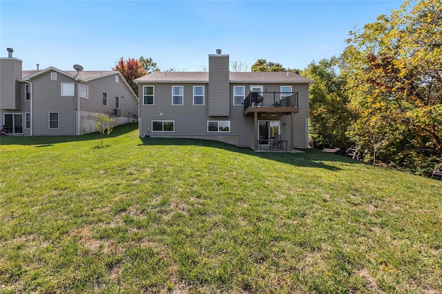 back of property with a lawn and a balcony