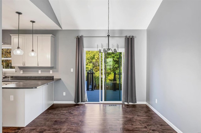 kitchen featuring white cabinetry, lofted ceiling, dark hardwood / wood-style flooring, and pendant lighting