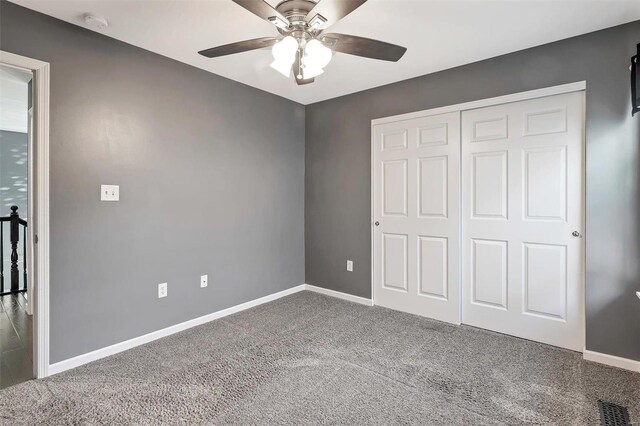 unfurnished bedroom featuring carpet, a closet, and ceiling fan