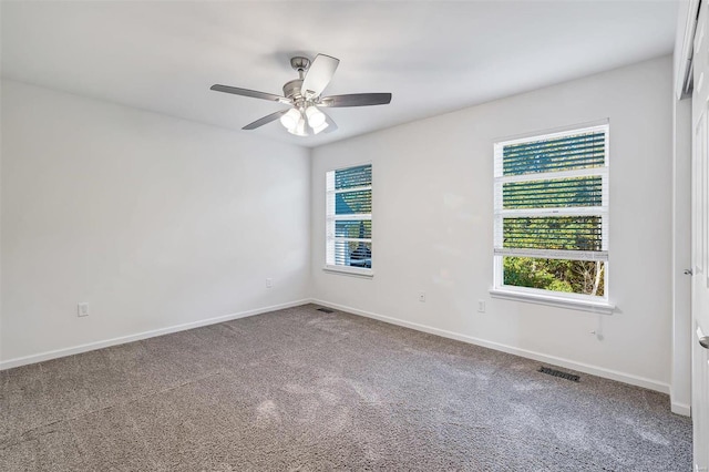 carpeted spare room featuring ceiling fan