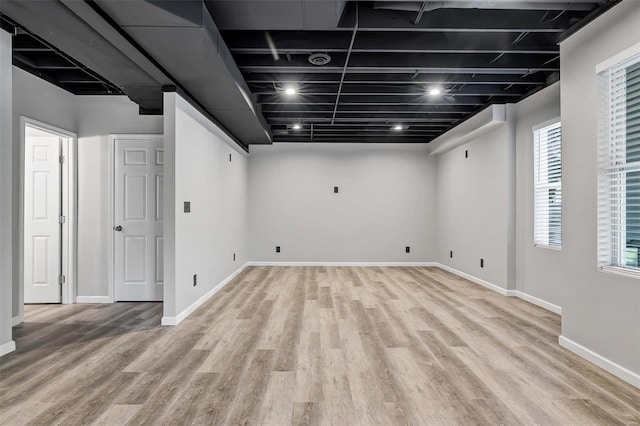 basement with a healthy amount of sunlight and light wood-type flooring