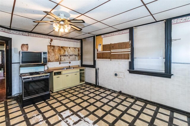 kitchen featuring ceiling fan, a paneled ceiling, and gas range gas stove