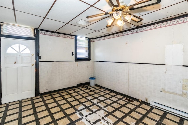 interior space featuring tile walls, a healthy amount of sunlight, and a baseboard radiator