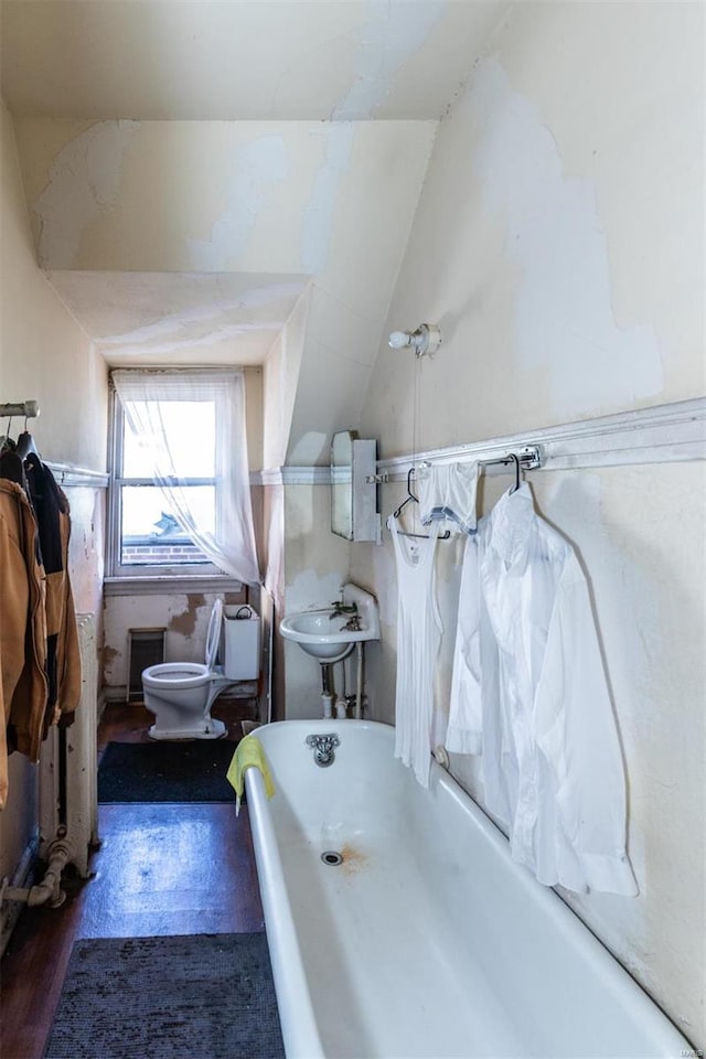 bathroom featuring lofted ceiling, toilet, wood-type flooring, sink, and a bathing tub