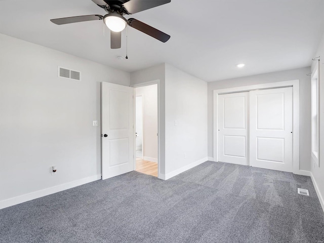 unfurnished bedroom with carpet, a closet, and ceiling fan