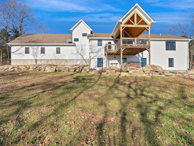 rear view of property featuring a yard, a hot tub, and a wooden deck