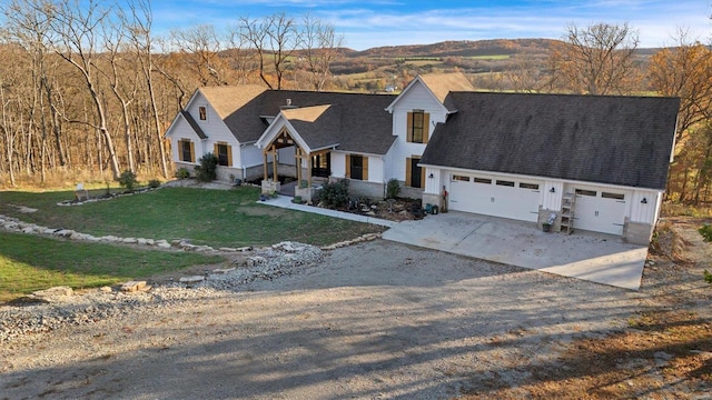 view of front of property with a mountain view, a front yard, and a garage