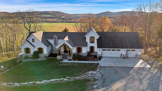 view of front of house with a mountain view, a front yard, and a garage