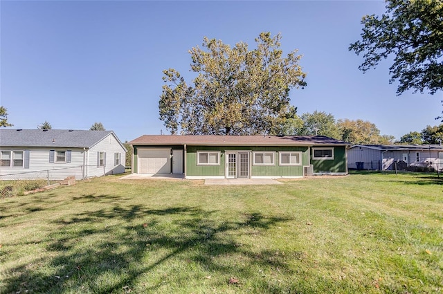 rear view of property with a yard and a garage