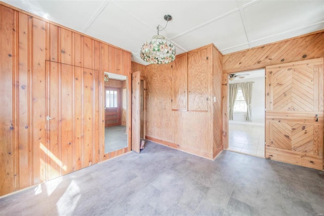 empty room featuring wood walls and plenty of natural light