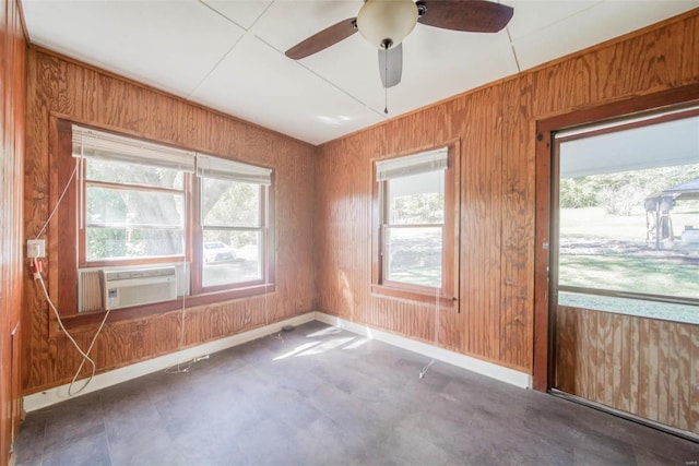 unfurnished room with cooling unit, wood walls, and ceiling fan