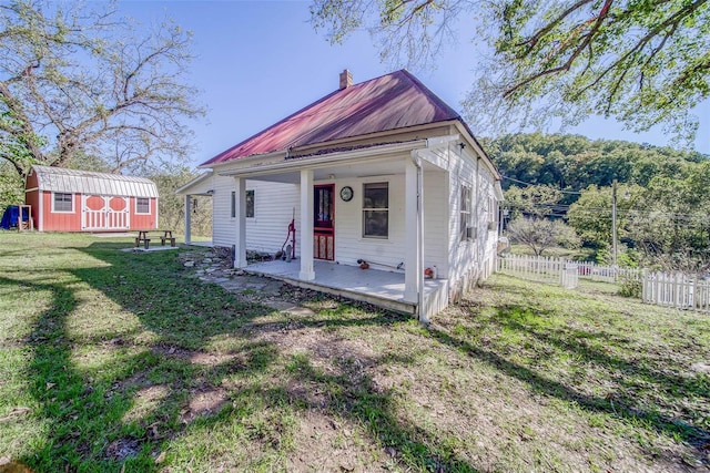 bungalow-style house featuring a front lawn and a shed