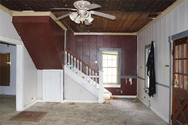 foyer with wood ceiling, wood walls, and ceiling fan