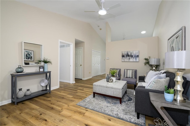 living room featuring hardwood / wood-style flooring, high vaulted ceiling, and ceiling fan