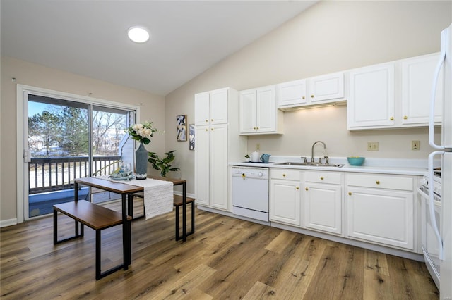 kitchen featuring sink, white cabinets, white appliances, and hardwood / wood-style flooring