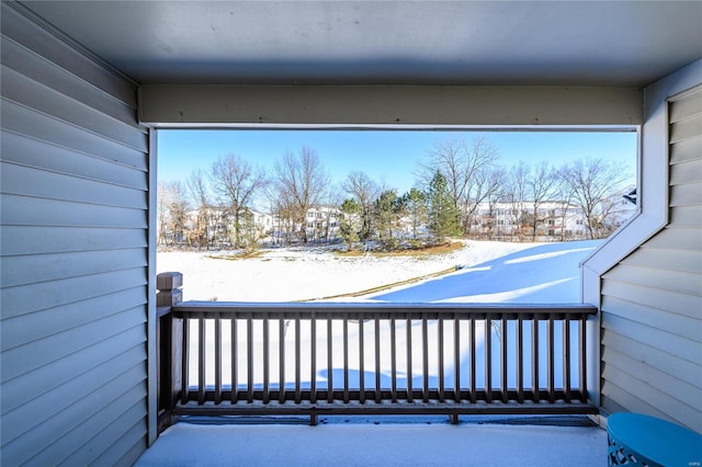 view of snow covered back of property