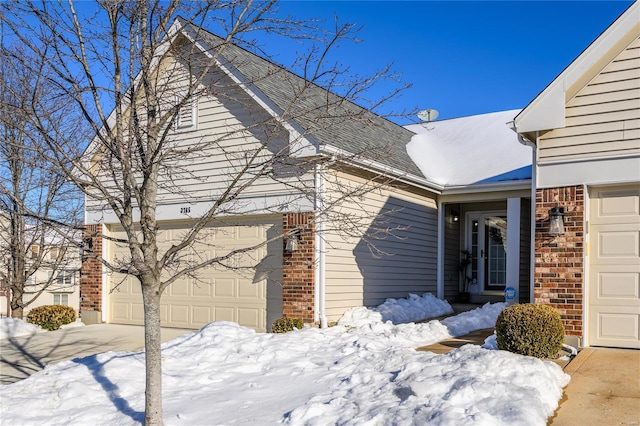 view of snow covered exterior with a garage