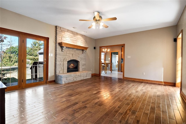 unfurnished living room with hardwood / wood-style flooring, a stone fireplace, and ceiling fan