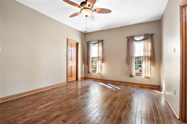 empty room featuring ceiling fan, plenty of natural light, and dark hardwood / wood-style floors