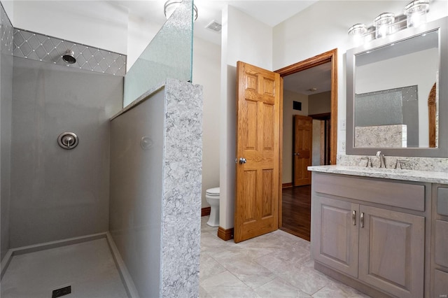 bathroom with vanity, a shower, and toilet