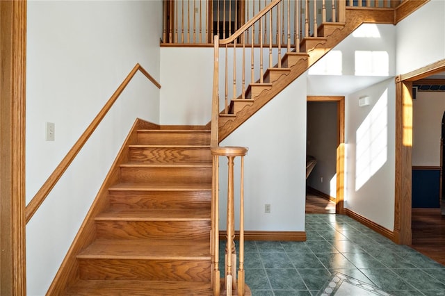 stairway featuring tile patterned flooring and a high ceiling