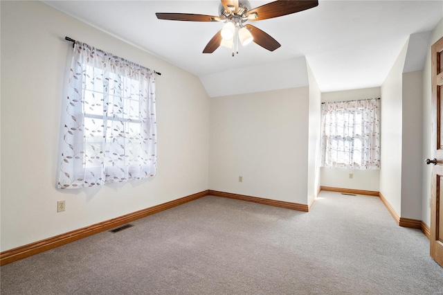 empty room with lofted ceiling, light carpet, and ceiling fan