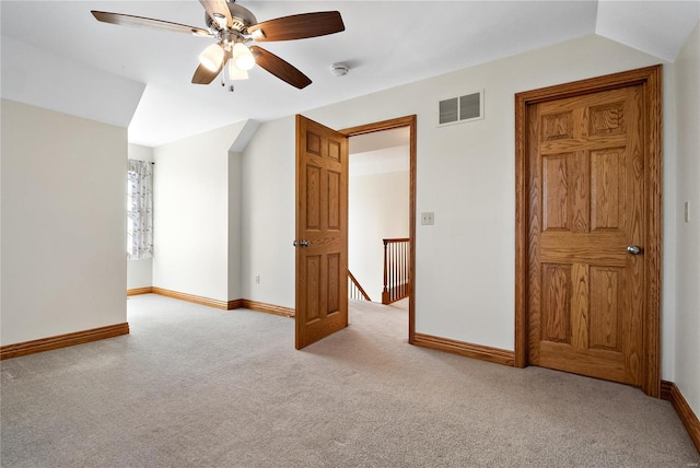 carpeted empty room featuring vaulted ceiling and ceiling fan