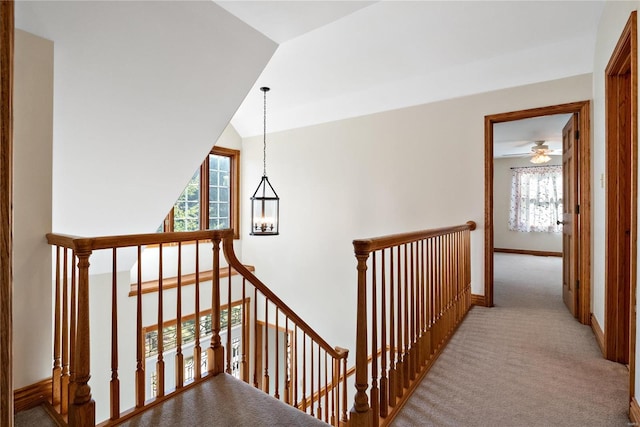 staircase featuring plenty of natural light, carpet flooring, and vaulted ceiling