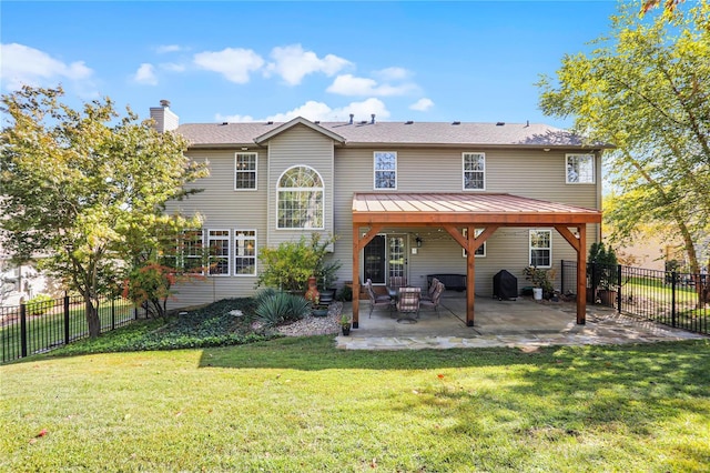 back of house featuring a patio area and a yard