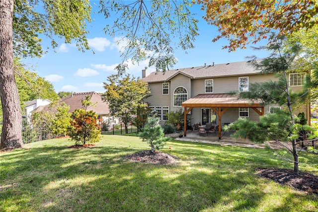 back of house featuring a lawn and a patio