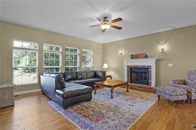 living room featuring ceiling fan, a brick fireplace, and hardwood / wood-style flooring